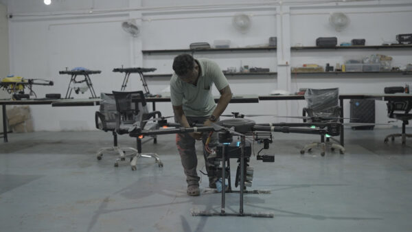Technician installing a Herewin battery in an agriculture drone inside a warehouse